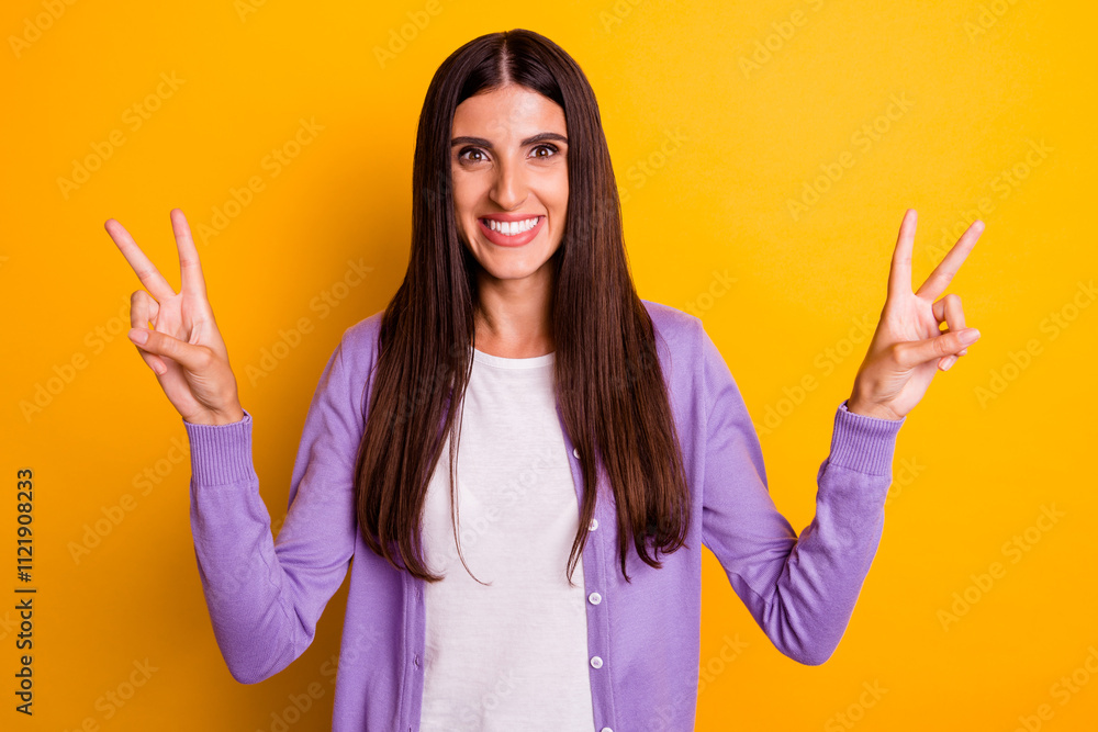 Photo of funny girl showing v sign gesture isolated on yellow color background Photo of funny girl showing v sign gesture isolated on yellow color background