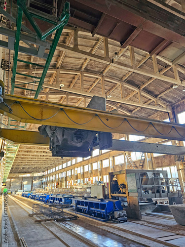 Interior of a modern industrial building with cranes and heavy machinery