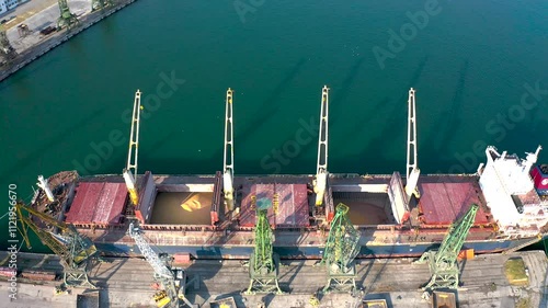 Top view from a drone of a large ship loading grain for export. Water transport 