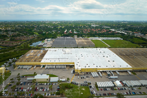 Aerial view of large commercial loading bay with many delivery trucks unloading and uploading retail goods for nationwide distribution. Global economy concept photo