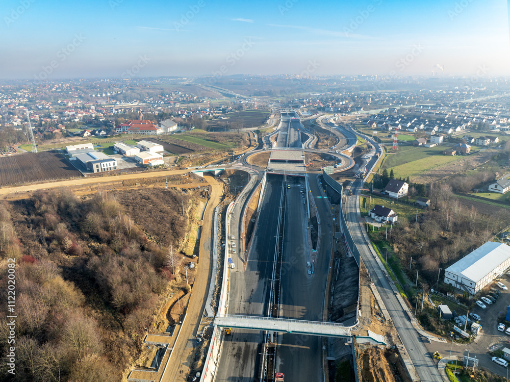 New Northern part of highway bypass around Krakow under construction. Fragment of S52 joining A4 with S7. Zielonki junction with tunnels and traffic circle. State in December 2024. Aerial view