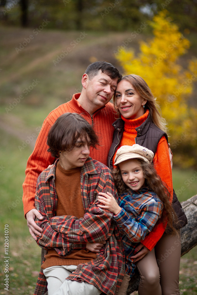 Fototapeta premium Family - mom, dad, daughter and son having fun in the autumn park