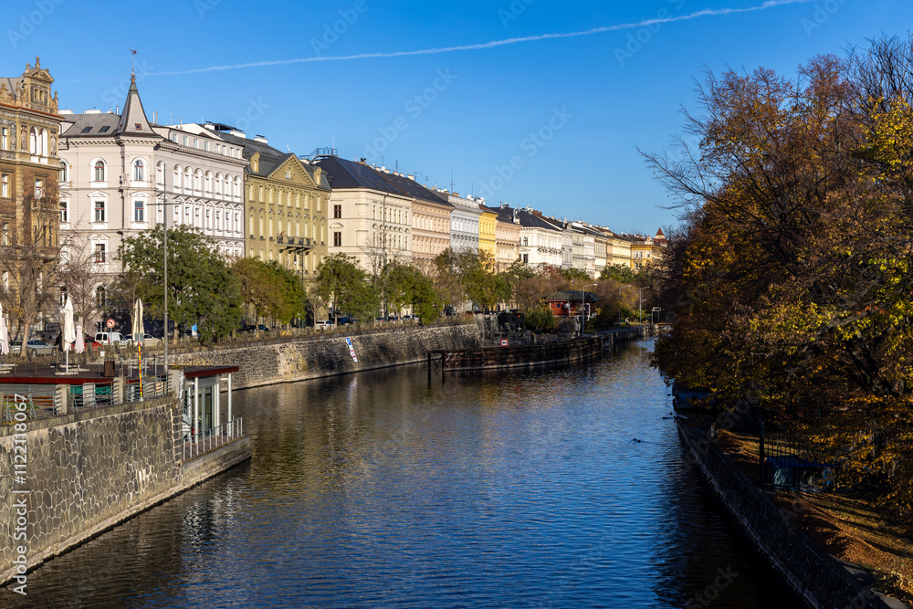 Fototapeta premium Prague embankment with colorful houses on a sunny autumn morning by the Vltava river canal in Prague