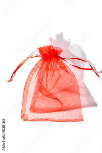 Fotografie Red organza pouch on white background. Vertical. Gift bag