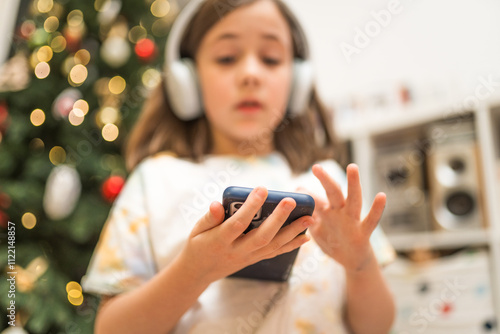 Child listen to a audio book or music with her headhones.  photo