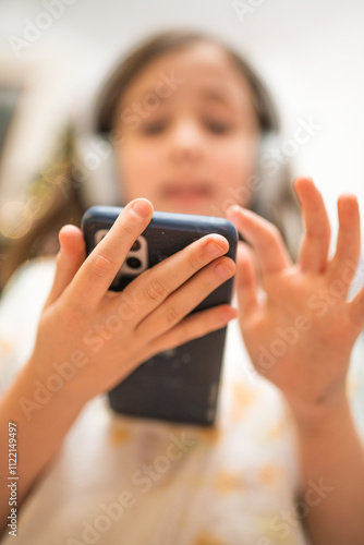 Child listen to a audio book or music with her headhones.  photo