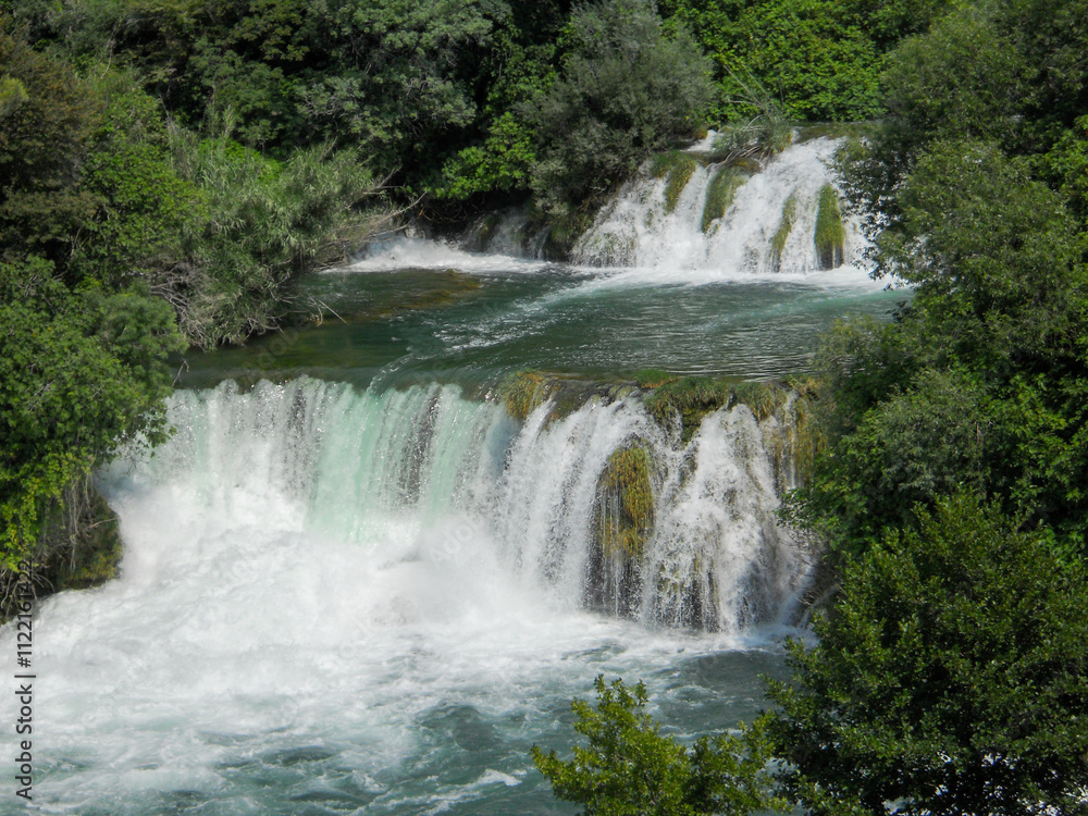 Obraz premium Beautiful waterfall surrounded by lush greenery
