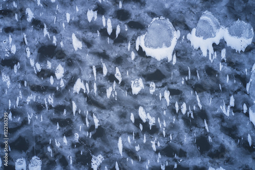 The river is bounded by ice. Beautiful ice surface with patches of crystal ice and light snow flurries. Shooting from a drone. photo