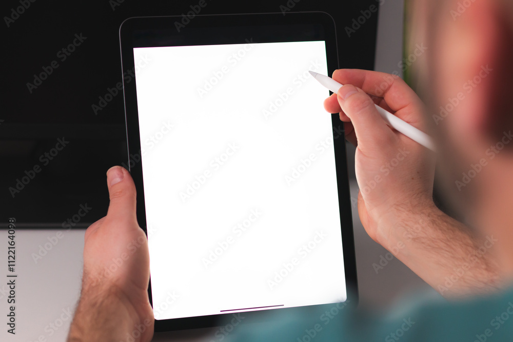 Mockup image of a man holding digital tablet with blank white desktop screen at home office Mockup image of a man holding digital tablet with blank white desktop screen at home office
