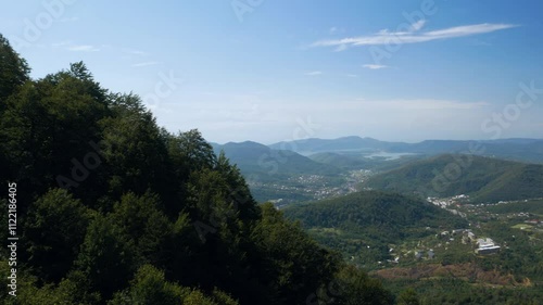 Scenic mountain landscape with rolling hills lush greenery clear blue sky
