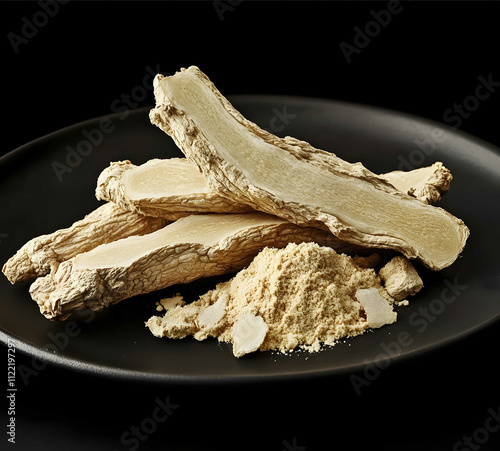 A black plate of dried pale white ginseng which is used for traditional Chinese medicine and herbal products with no background text or logo The picture shows the who photo