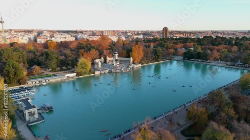 Stunning aerial view of El Retiro Park, highlighting its serene waters surrounded by vibrant autumn colors that beautifully paint the landscape in the heart of Madrid, Spain. Europe