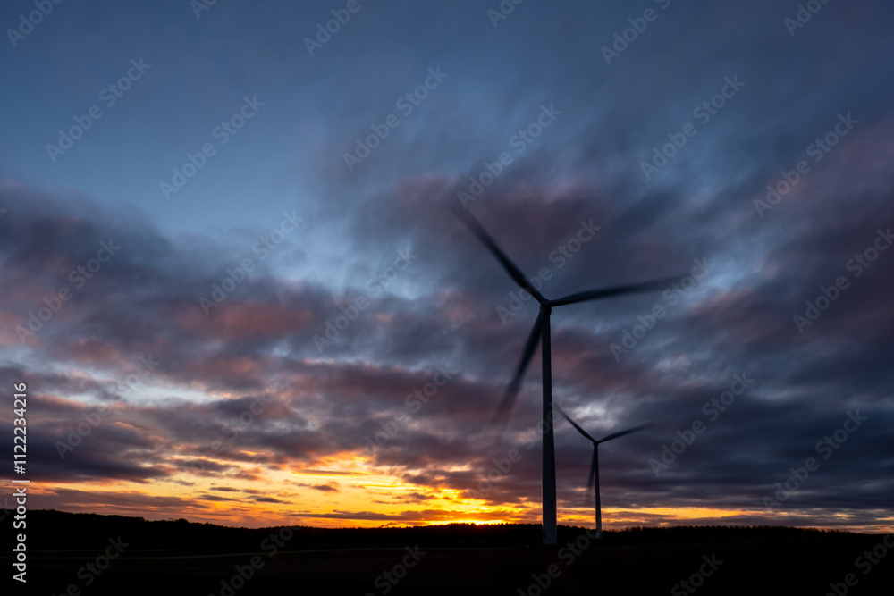 Obraz premium Spinning wind turbines at sunrise