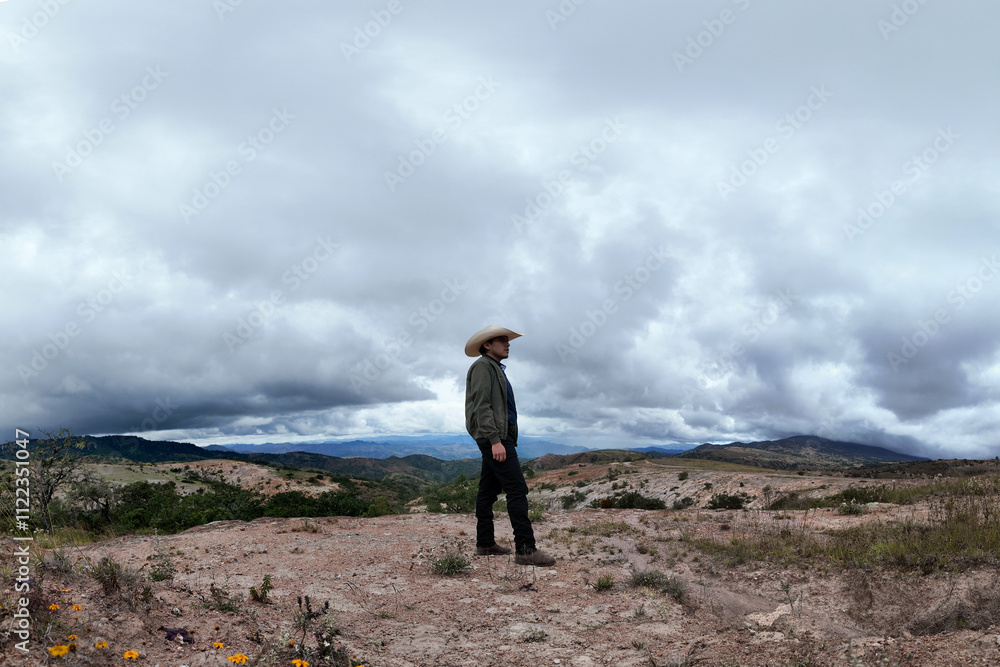 Obraz premium Standing alone amidst dramatic clouds in a remote landscape