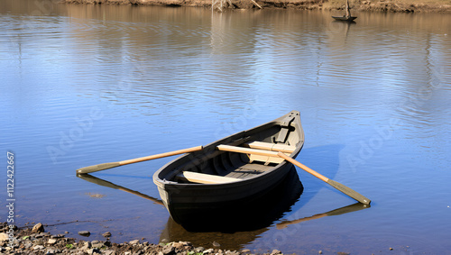 Rowing boat moored to the shore. Spring on the river. Floating.