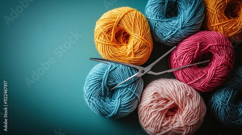 Colorful Yarn Balls with Scissors on a Teal Background Perfect for Crafting, Knitting, or Sewing Projects in a Creative Work Space photo