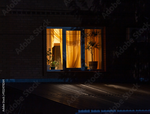 The light is on in the window of a private house.