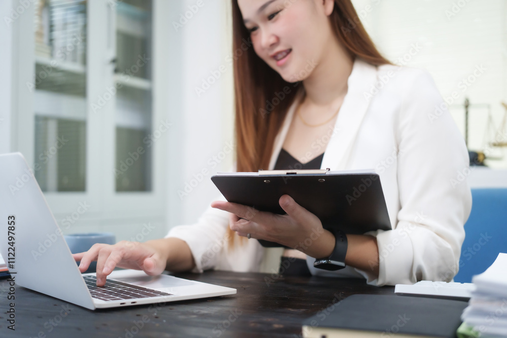 A young, professional businesswoman working at her desk in an office, providing online legal consultancy for disputed civil cases, addressing lawsuits, loan defaults, unfair dismissals, and property A young, professional businesswoman working at her desk in an office, providing online legal consultancy for disputed civil cases, addressing lawsuits, loan defaults, unfair dismissals, and property