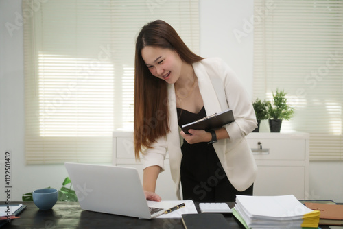 A cheerful businesswoman works at her office desk as a legal consultant, handling online civil cases, including debt disputes, unfair dismissals, foreclosures, land redemptions, with professionalism photo