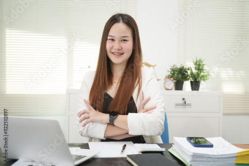 A cheerful businesswoman works at her office desk as a legal consultant, handling online civil cases, including debt disputes, unfair dismissals, foreclosures, land redemptions, with professionalism photo