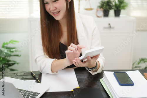 A cheerful businesswoman works at her office desk as a legal consultant, handling online civil cases, including debt disputes, unfair dismissals, foreclosures, land redemptions, with professionalism photo