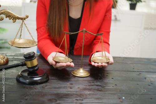 A cheerful businesswoman smiles while holding a gavel at her desk, working as a legal consultant in an office, resolving civil disputes like debt cases, dismissals, foreclosures,and evictions online photo