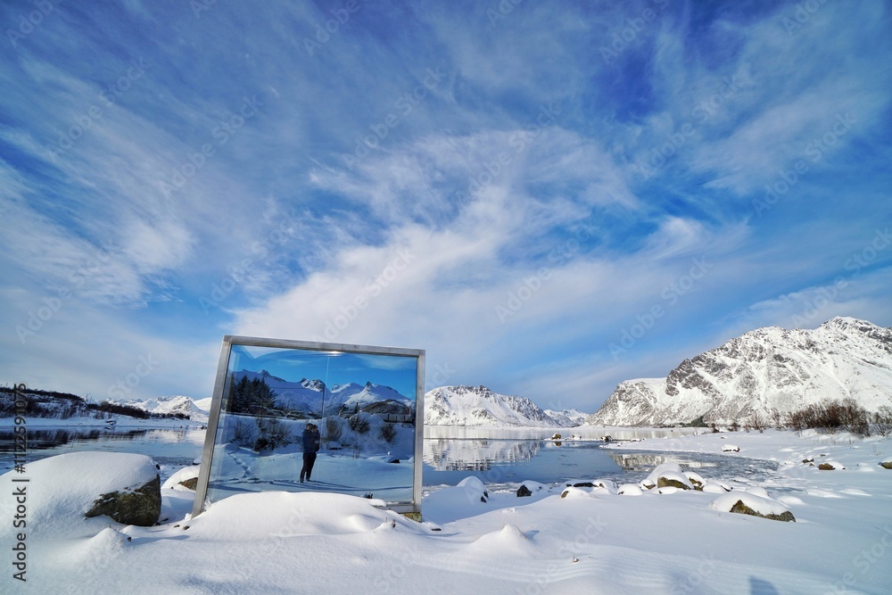 A mirror reflect the lake and snow mountain at Norway.