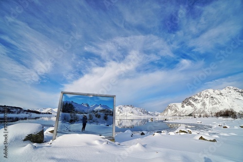 A mirror reflect the lake and snow mountain at Norway.