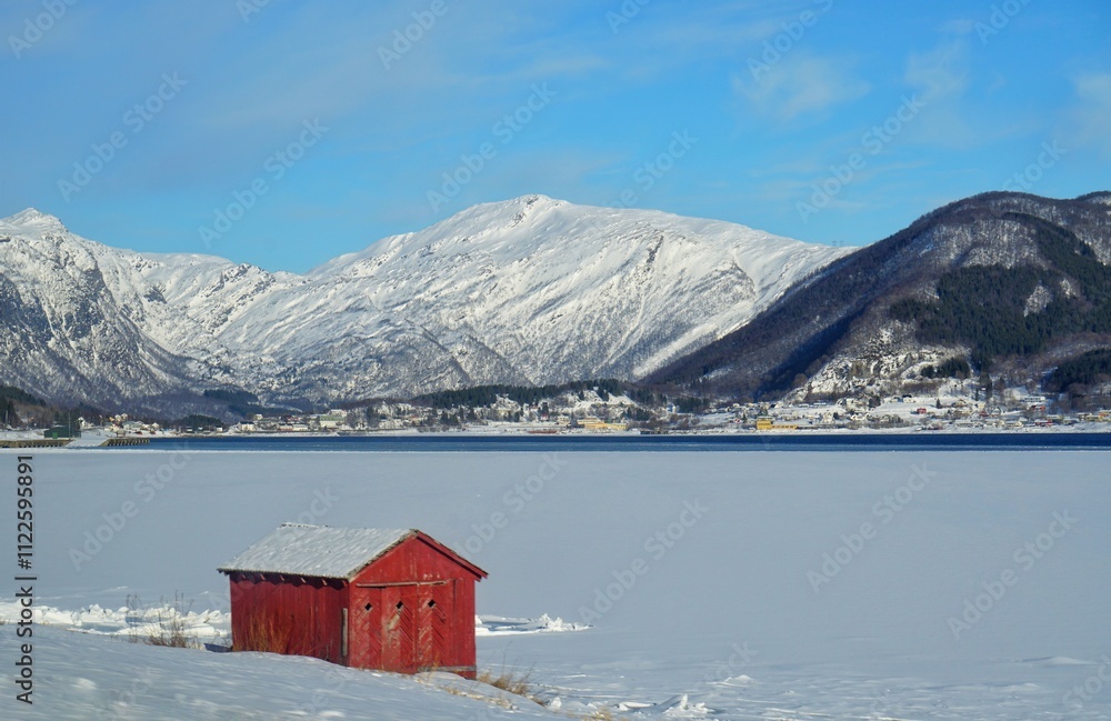 A red house with snow mountain background.