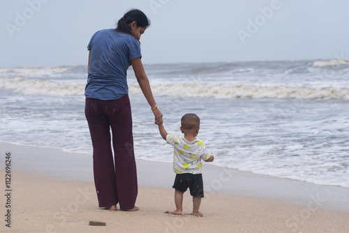 Single mother with baby at beach. Sea trip picnic insurance future NPS Vatsalya life education savings family love care upbringing independent freedom working homemaker job playing cuddling