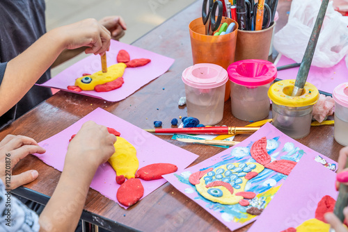 children's hands share an application on the table for creativity