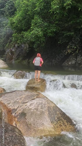 Asian woman admiring nature and waterfall