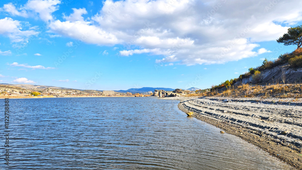 Fototapeta premium In autumn, a view of the Lake Emre which is a serene natural oasis, surrounded by lush greenery and ancient rock formations in the heart of Phrygian Valley in Afyonkarahisar.