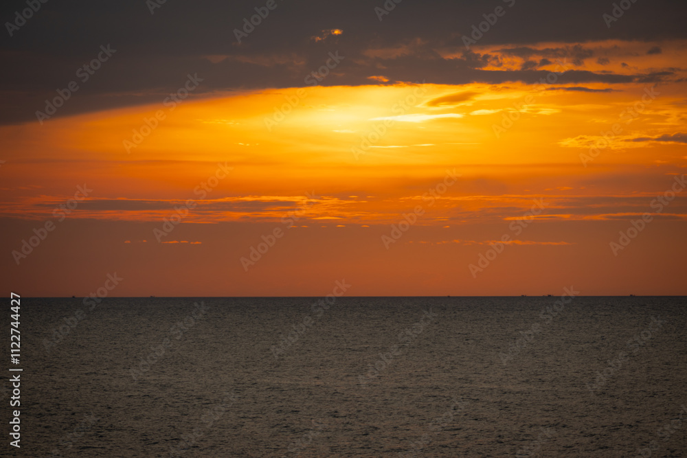 Fototapeta premium A serene seascape with a distant island silhouetted against the twilight sky