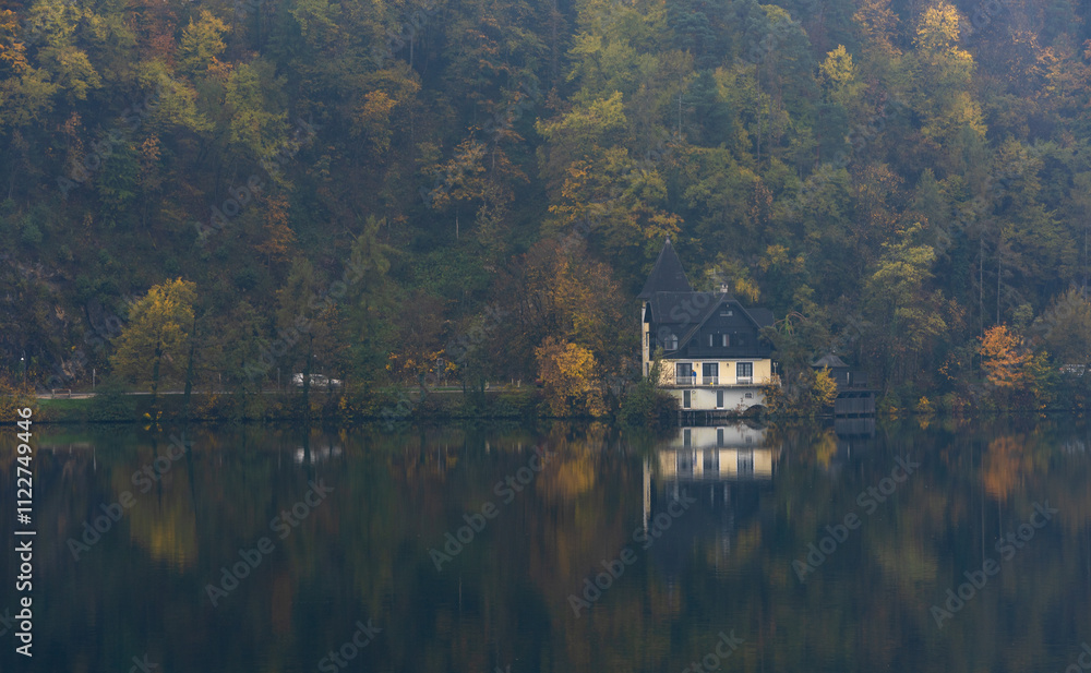 Fototapeta premium Fog rolling over the lake and forest in autumn. Lake Bled Slovenia