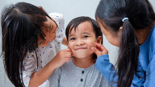 happy three children, pinched little boy cheeks