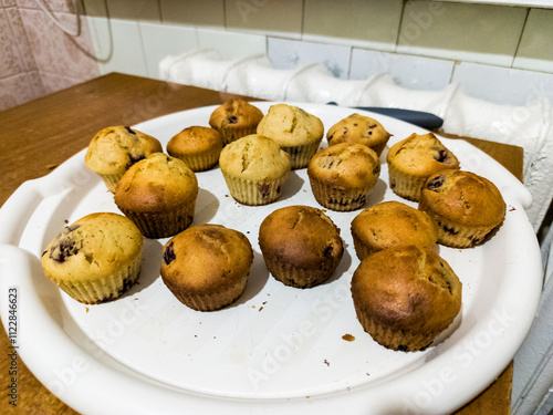 A white plate topped with muffins sitting on top of a wooden table photo