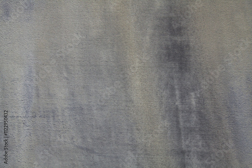 An old and shabby surface, background of dence knitted fabrics. Backdrop of wicker fiber, thick tarpaulin. Texture of fabric coating (covering) of ancient, faden tarpaulin. Grey waterproof canopy