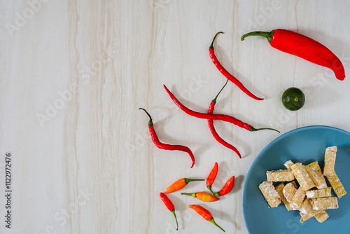 Top view of food background with chili, lime, and tempeh on marble background