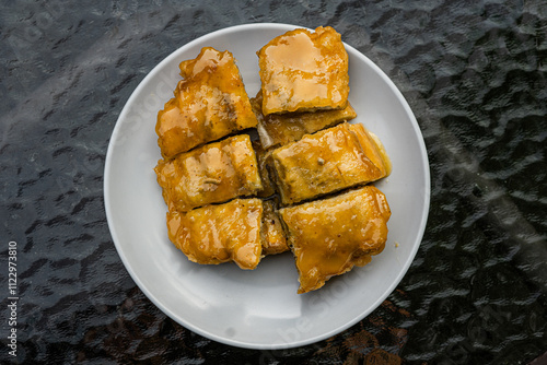 Top view of a signature dish of Pontianak, Indonesia called srikaya fried banana on a glass table