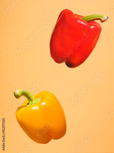 Two peppers, one yellow and one red, floating in the air against a yellow background. Captured in a vibrant pop-art style, they add a bold, playful touch to the scene.
