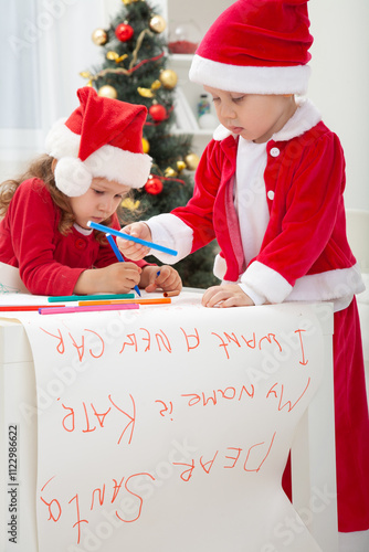 Obraz na płótnie little kids in Santa hat writing letter to Santat under the Christmas tree w salonie