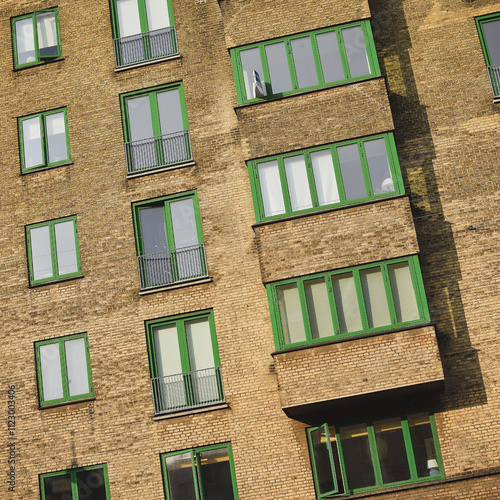 Full frame image of a residendial block with green windows.