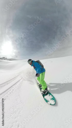 SELFIE: Young male tourist shreds the fresh powder snow during a catboarding trip in the spectacular Rocky Mountains. Fearless snowboarder rides down untouched terrain in the mountains of Canada. photo