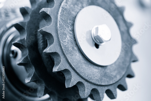 A gear with a bolt on it. The gear is silver photo