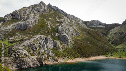 Lake enol reflecting surrounding mountains in covadonga lakes, picos de europa national park, asturias, spain photo