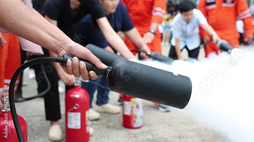 Employees firefighting training, Concept Employees hand using fire extinguisher fighting fire closeup	
