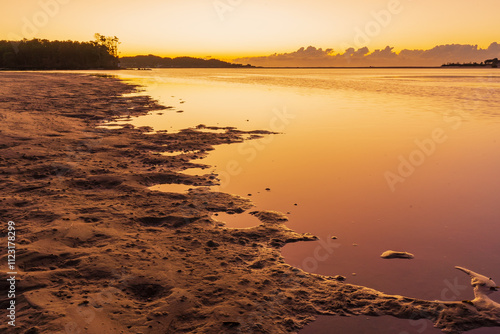 Low angled view of sand falts and puddles at low tide at sunrise photo