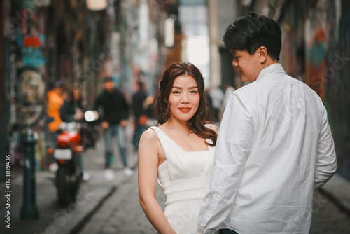 Young engaged couple posing together in Hosier Lane, iconic graffiti laneway in Melbourne photo