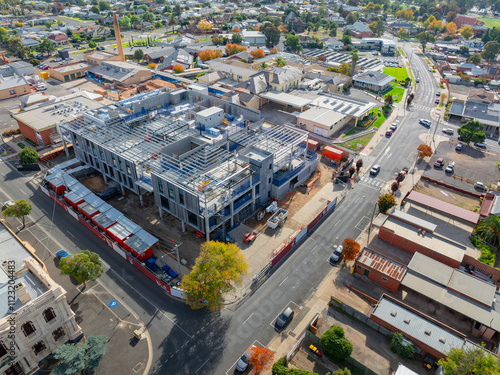 Aerial view of multi level construction site alongside existing city buildings photo